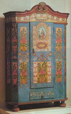 an old wooden cabinet with colorful designs on it