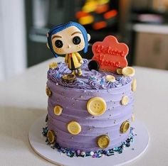 there is a purple cake with a doll on top