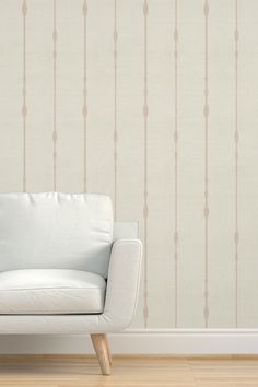 a white couch sitting in front of a wall with lines painted on the wall behind it