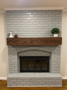 a white brick fireplace with a wooden mantle