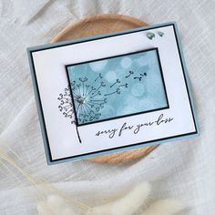 a card with a dandelion design on it