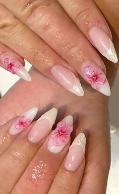 two hands with pink and white nail designs on them