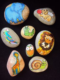 some rocks with pictures of different animals painted on them and one has an elephant, giraffe, lion, turtle, bird