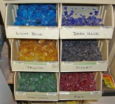 several boxes filled with different colored glass beads