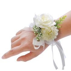 a white wrist corsage with flowers on it