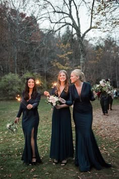 three women in long dresses are standing together with sparklers on their heads and holding bouquets