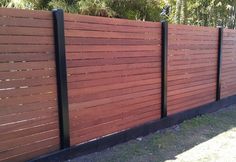 a wooden fence with black metal posts