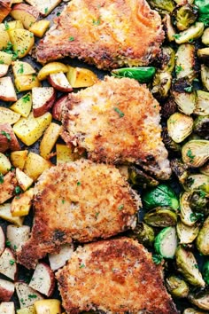 some meat and vegetables are on a sheet pan