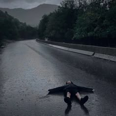 a person laying on the road in the rain