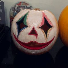 a painted pumpkin sitting next to an orange