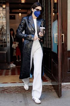 a woman wearing a face mask while walking out of a building