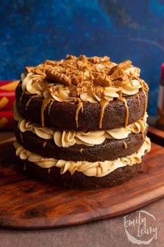 a chocolate cake with peanut butter frosting and walnuts on a wooden platter