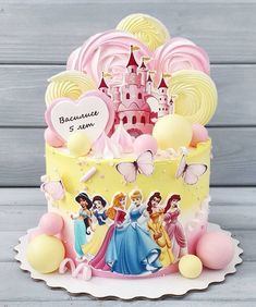 a birthday cake decorated with princesses and balloons