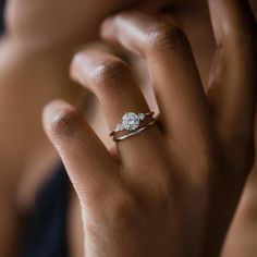 a woman's hand with a diamond ring on it