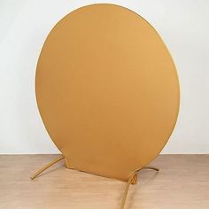 a large yellow object sitting on top of a wooden floor next to a white wall