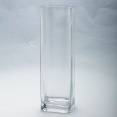 a tall glass vase sitting on top of a white tablecloth covered floor with no one in it