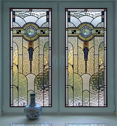 two large stained glass windows sitting next to each other on top of a white counter