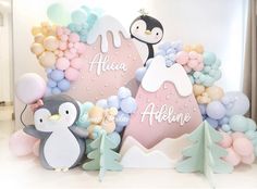 a penguin and penguinie themed backdrop with balloons