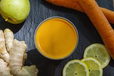 carrots, apples, lemon and ginger juice on a table