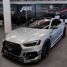 a silver car is parked in a showroom