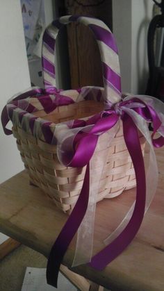 a basket with purple and white stripes on it sitting on top of a wooden table