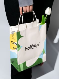 a person holding a shopping bag with a flower in it