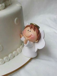 a white cake with an angel figurine next to it