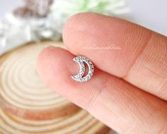 * Sparkly Crescent Moon CZ Ear Piercing, 16G Cartilage earrings, Surgical Steel.⚠️This listing is for ONE piece, NOT a pair ⚠️* Materials : Post - 316L Surgical Steel , Top - Copper with Nickel-Free plating, long lasting color.* Closure type :  Screw Ball back* Dimensions:   Moon 6.5 x 7.5 mm* Post length : 6 mm* Bar thickness : 16 gauge (1.2 mm)* Ball back size : 16G / 3 mm **Measurements are an approximation. Size, shape and color can vary slightly from above dimensions.**★★★ Get extra ball ba Moon Shaped Cartilage Earring As Gift, Moon Shaped Cartilage Earring For Gift, Moon Shaped Single Cartilage Earring As Gift, Gift Moon Shaped Single Cartilage Earring, Internally Threaded Crescent Piercings As A Gift, Internally Threaded Crescent Piercings For Gift, Hypoallergenic Moon-shaped Cartilage Earrings As Gift, Ear Piercings Gauges, Black Hoops Earrings