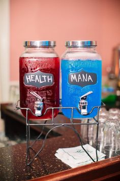 two jars filled with liquid sitting on top of a counter