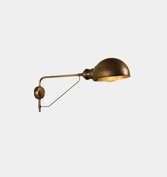 an antique brass wall light with a metal arm and two lights on each side, against a white background