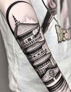 a man's arm with a black and white tattoo design on the left forearm