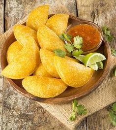 some food that is in a bowl on a table with limes and cilantro