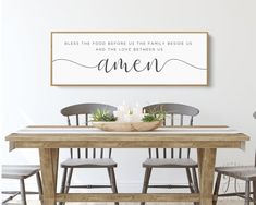 a dining room table with four chairs and a framed sign above it that says gather