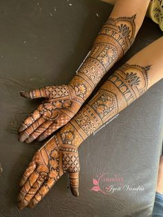 two hands with henna tattoos on them