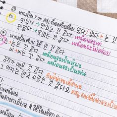 an open notebook with writing on it and colored pencils next to it, all written in different languages