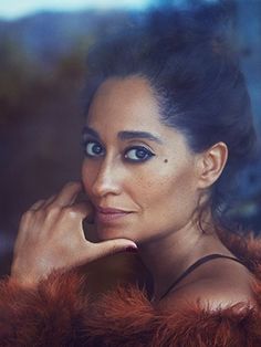 a woman in a fur coat looking out the window with her hand on her face