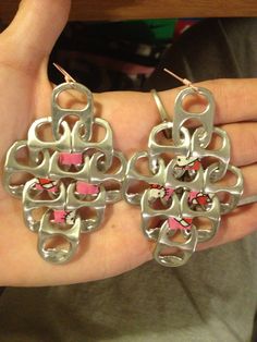 two pairs of hello kitty earrings are shown in the palm of someone's hand