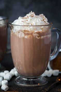 hot chocolate in a glass mug with marshmallows around it