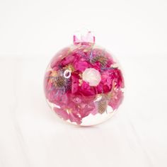 pink flowers in a clear vase on a white surface