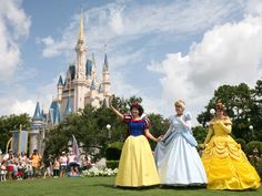 three women dressed in princess dresses standing next to each other with their arms outstretched and one holding her hand out