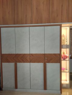 the interior of a room with wooden paneling and sliding doors that open to reveal a refrigerator