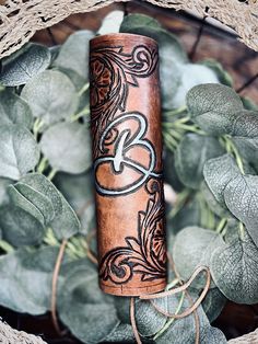 a roll of leather with the letter k on it sitting in front of some leaves