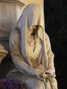 there is a statue with a cloth draped over it's head and sitting on the ground