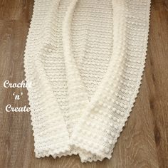 a crochet sweater is shown on a wooden floor with the words crochet in