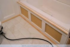 a bath tub sitting next to a white toilet in a bathroom with tile flooring