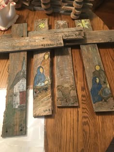 wooden crosses with paintings on them sitting on a table