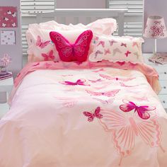 a bed with pink and white butterflies on the comforter, pillows and pillow cases