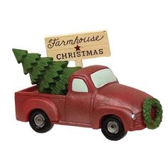 a red truck with a christmas tree in the bed and a sign that says farmhouse