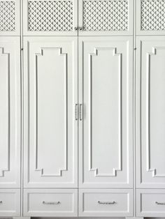 a white armoire with drawers and doors on each side, in front of a wall