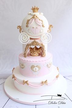 a three tiered cake with gold and pink decorations